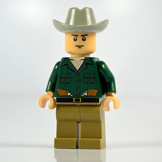 LEGO minifigure in a cowboy outfit with a green shirt, beige pants, and a white hat on a white background.