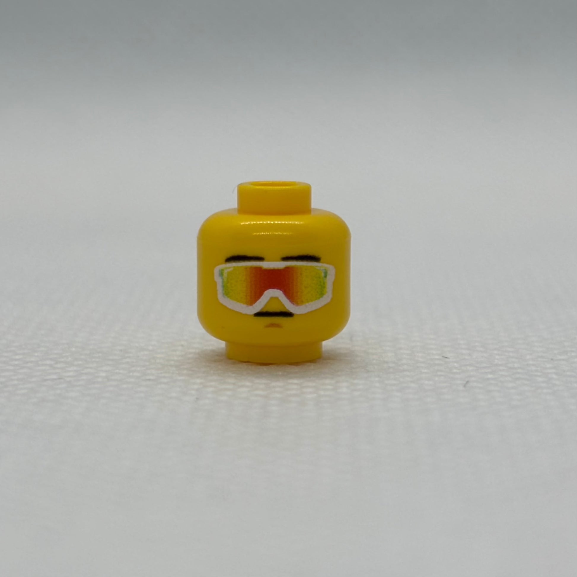 Yellow LEGO vipers head toy piece against white background