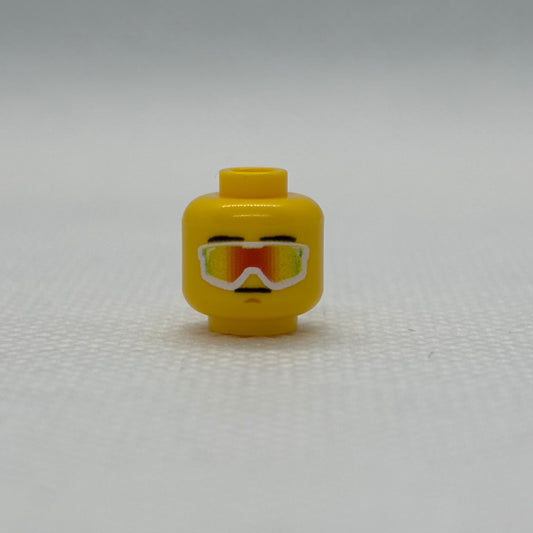 Yellow LEGO vipers head toy piece against white background