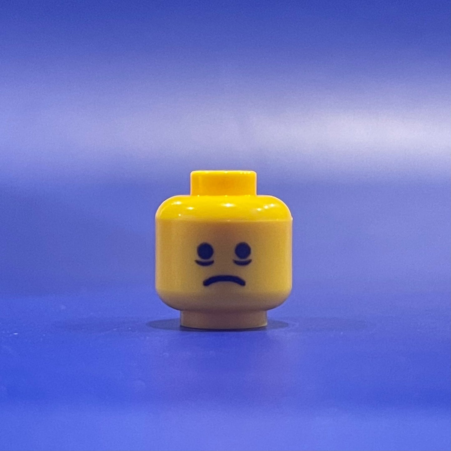 Classic Exhaustion Head LEGO minifigure facial expression on yellow head piece against blue background