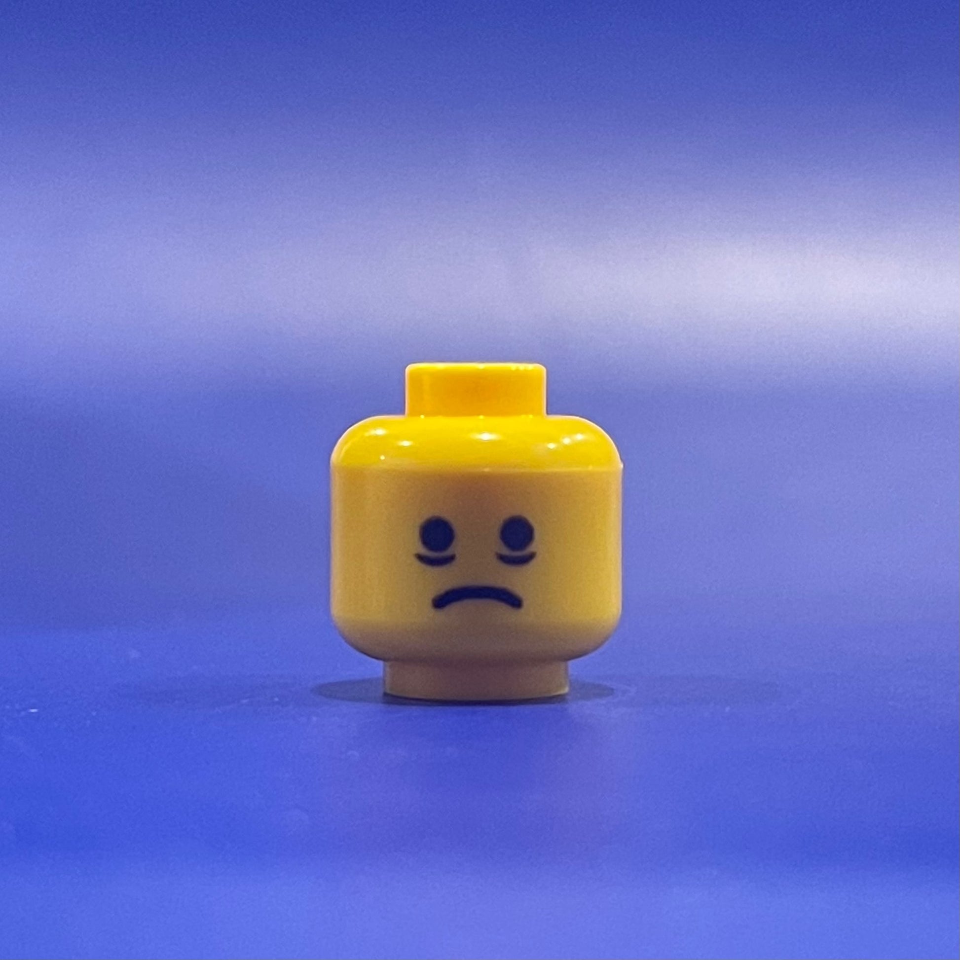 Classic Exhaustion Head LEGO minifigure facial expression on yellow head piece against blue background