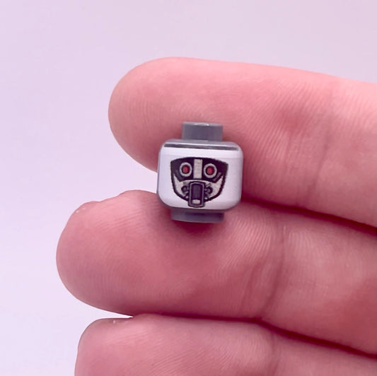 Hand holding a LEGO Classic Robot Guard Head piece with printed robotic face details