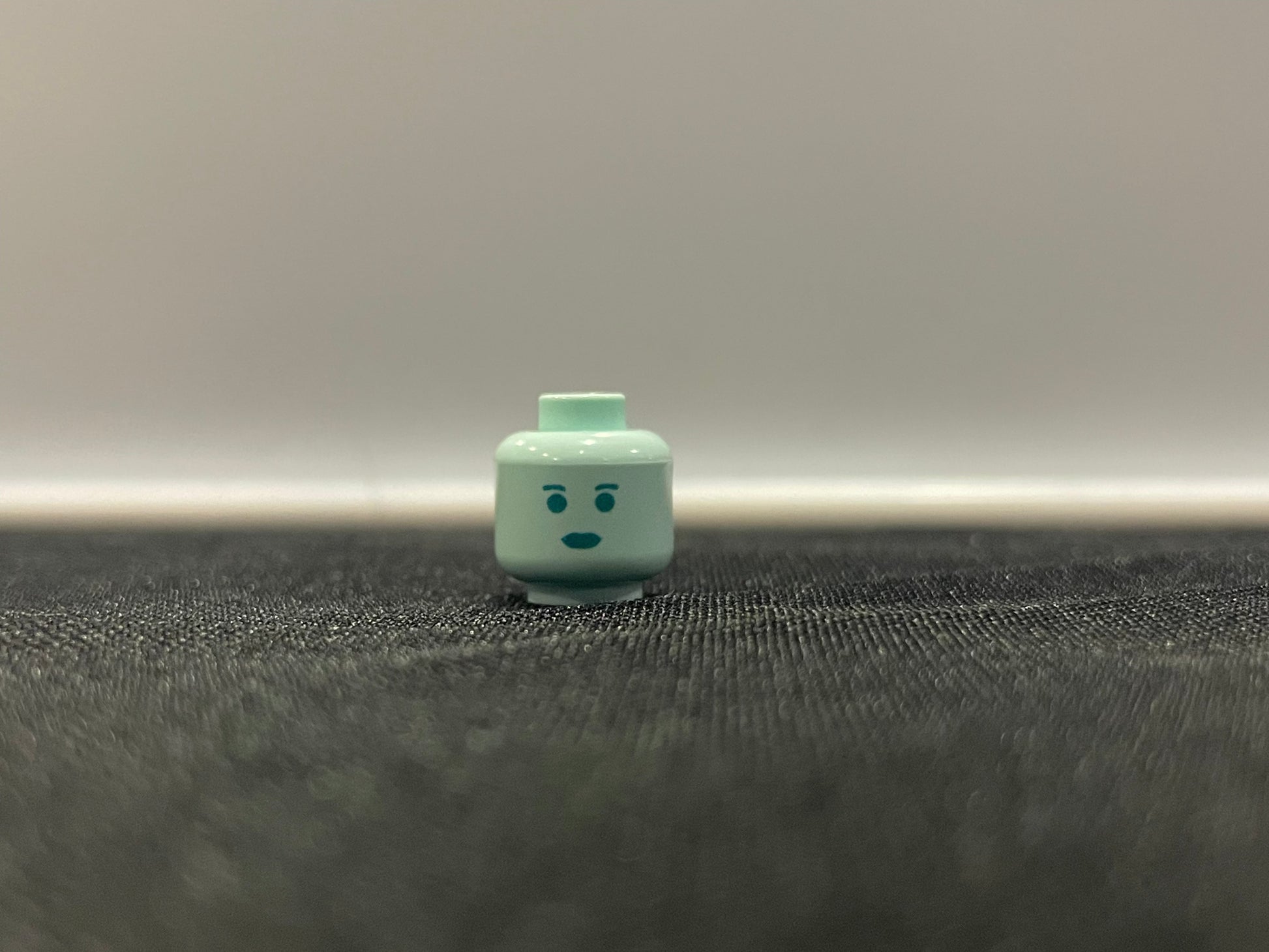 Classic Hologram Leah Head LEGO minifigure face piece on black surface
