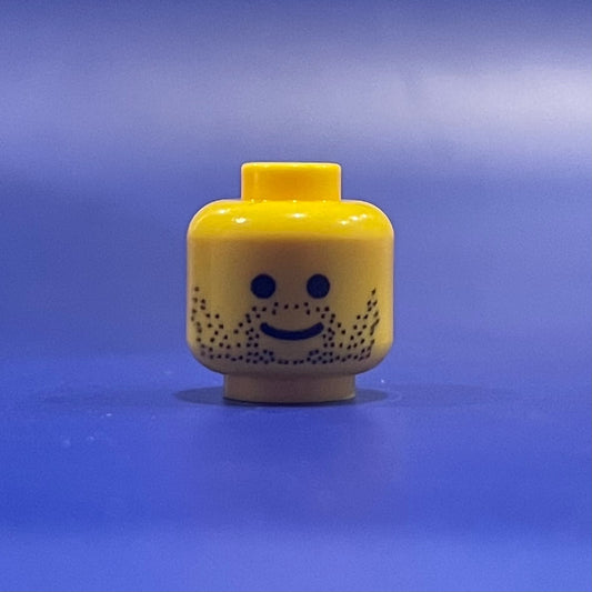 LEGO Classic Stubble Head minifigure with smile and stubble beard on blue background