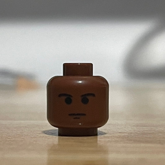 Classic LEGO pilot minifigure head with brown skin tone and serious expression