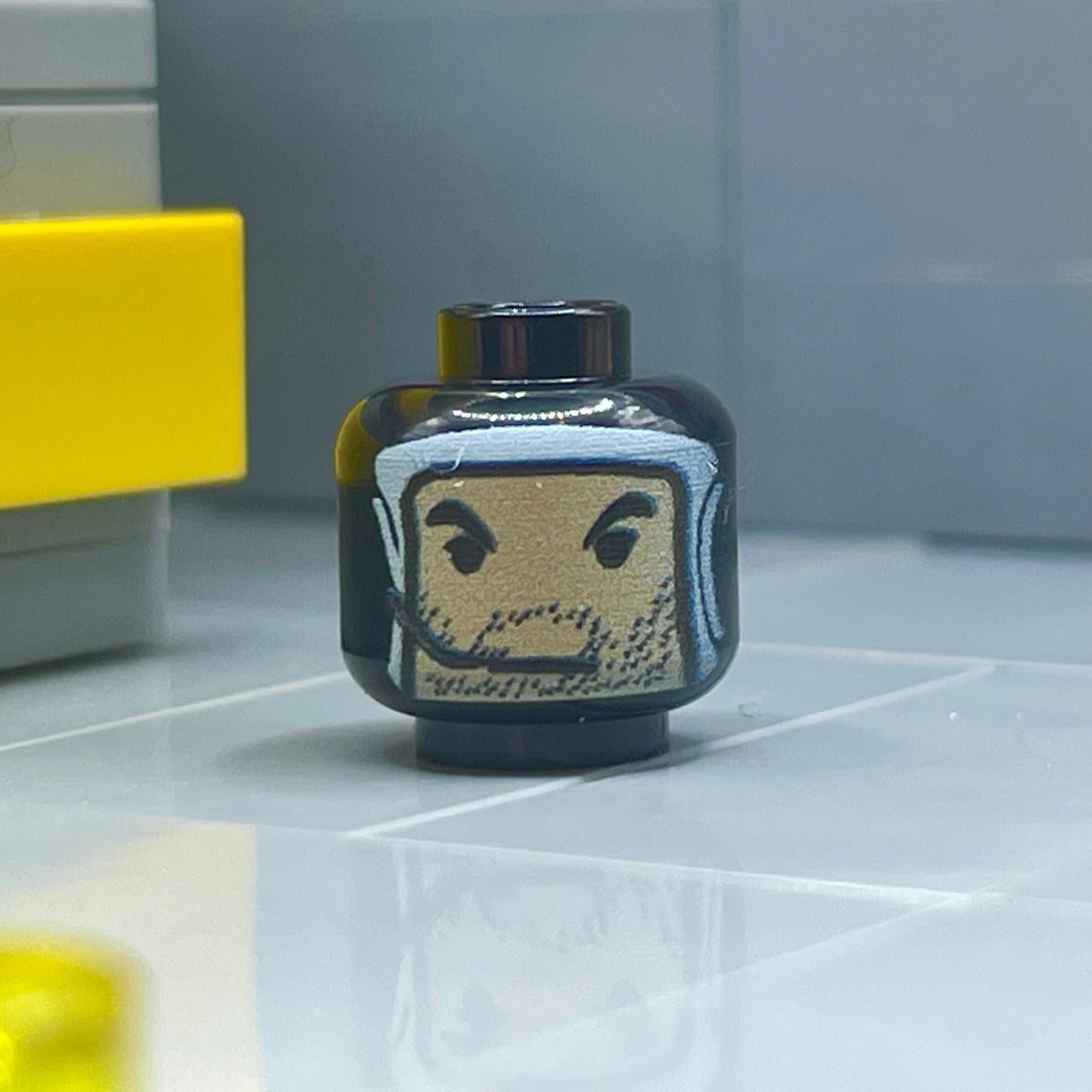 Classic Derpy Fett Head LEGO minifigure head with beard and smirk expression on tiled surface