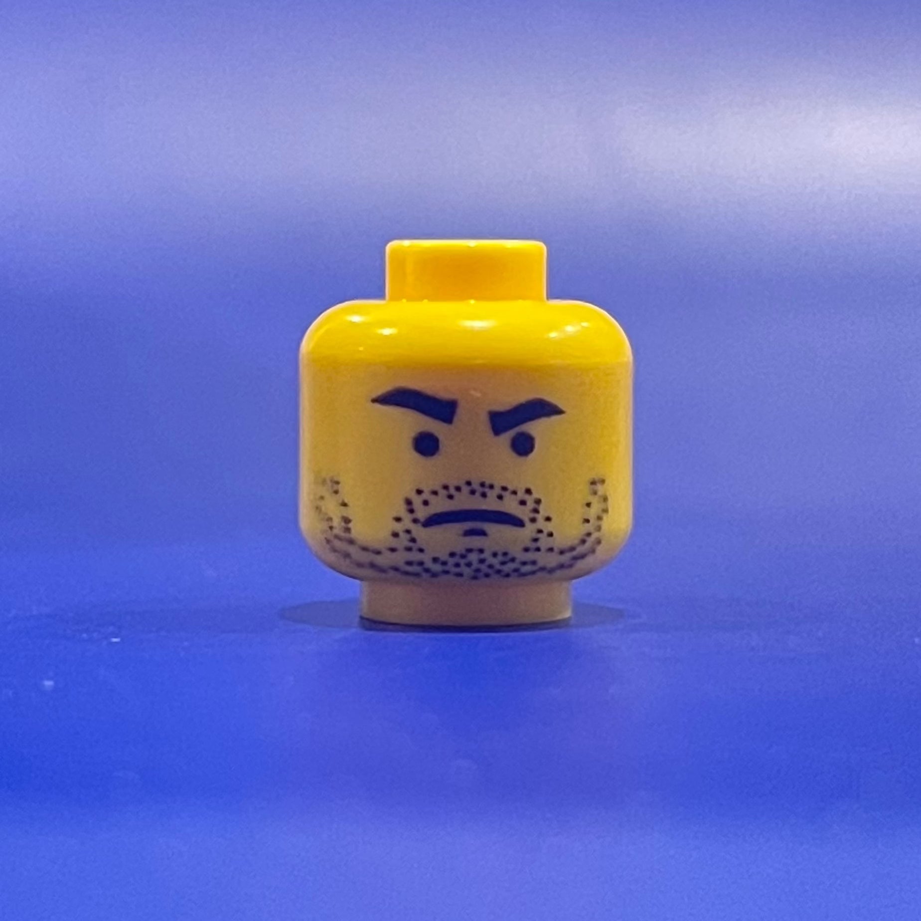 Classic Cantina Server Head Yellow LEGO minifigure face with stubble and stern expression on blue background